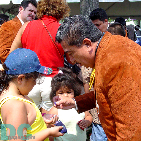 After his group's performance, this Mariachi band member takes a moment with an inquisitive audience member.