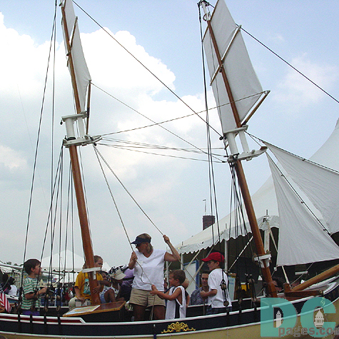 Also an educational festival, this woman is teaching young children the ways and means to man a boat.  The children enjoy the simulation, and gain interesting knowledge in the process.