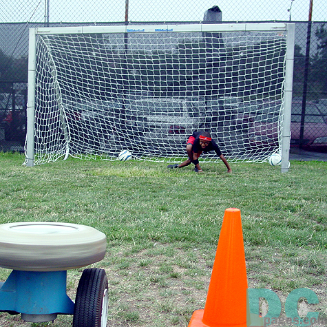 Young kid scrambles to try and make a save.