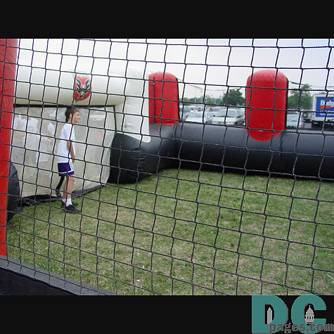 Big air filled mini stadium has this kid playing goal keeper against his friends.