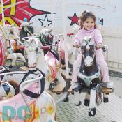 A future 'Jay Lo' rides a black and white pony on a classic mini Carousel.