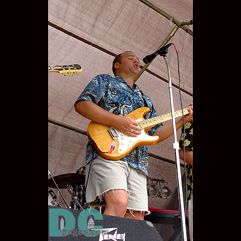 The lead singer of a local band plays for his audience.