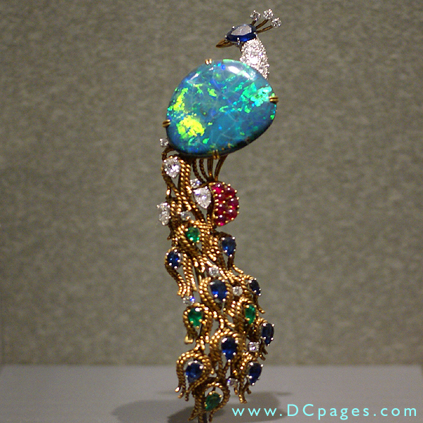 Opal with diamond and corundum. This pin appears alive and sparkling in all the colours of the rainbow. 