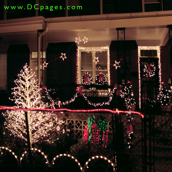 Holiday wreaths, stars, ribbon, garland, presents, and very brite white Christmas tree on display.