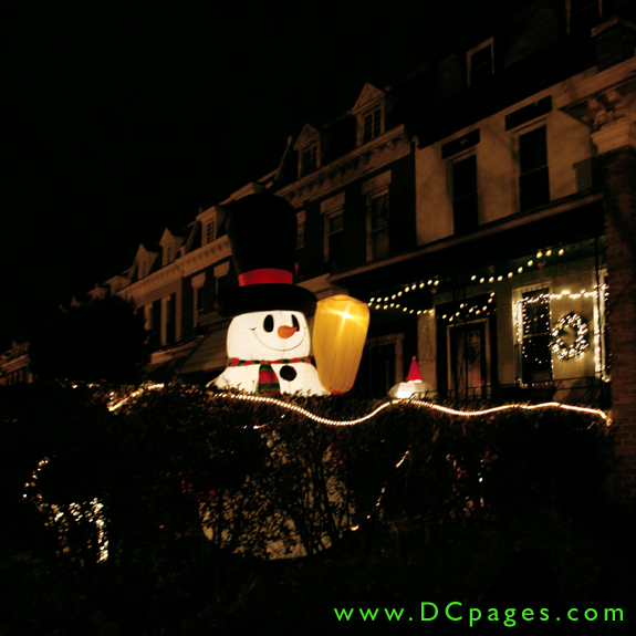 A giant smiling inflatable snowman holds a broom up ready waiting for the season's first snow fall.