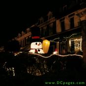 A giant smiling inflatable snowman holds a broom up ready waiting for the season's first snow fall.