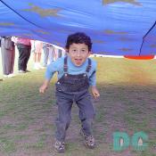 Smithsonian Kite Festival - Child having fun walking under American Flag