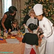 Michelle Obama assists a little girl at a craft station