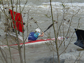 A competitor pulling hard through the finish line flags.