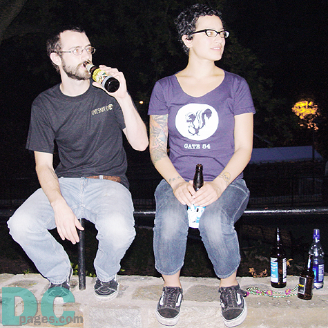 A fashonable couple was enjoying the music with beers.