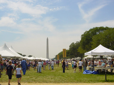 Visitors exploring the many tents filled with crafts, presentations, food, music, and the Washington Monument in the background
