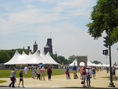 The Timbuktu Stage, where patrons have the opportunity to experience Malian music and dance.  The Smithsonian Castle is seen in the background and a Malian adobe gate welcomes visitors to experience the culture of Mali.