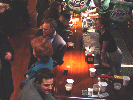 Patrons and bartenders converse along Fin Mac Cool's solid 43 foot long cherry wood bar.