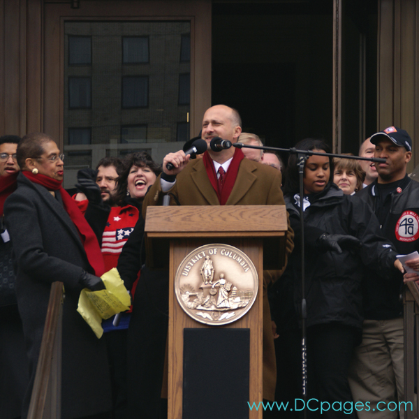 DC Vote Executive Director, Ilir Zherka, is watched closely by DC Congresswoman Norton as he addresses crowd before march to Capitol Hill to demand Congressional Voting Rights for DC residents. "The DC voting rights movement is like a rally race through time, with each generation passing the baton to the next generation."