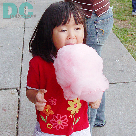 A pretty girl had a bite of her pink Wata-ame. 