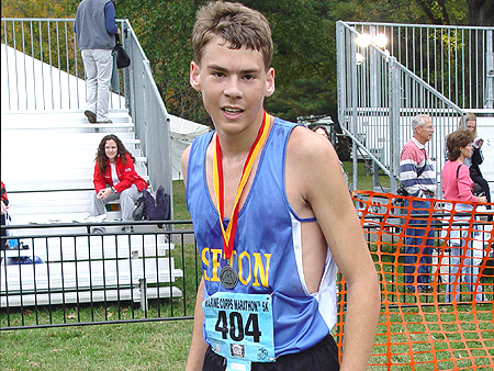 A tired Marathon runner smiles for the camera.
