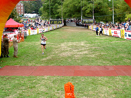 People crowded around the finish line waiting for the runners to arrive.