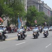 The motorcycle police ride by in a roaring armada.  