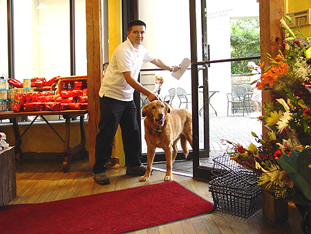 Wiley is greeted at the door by a Marvelous Market employee.