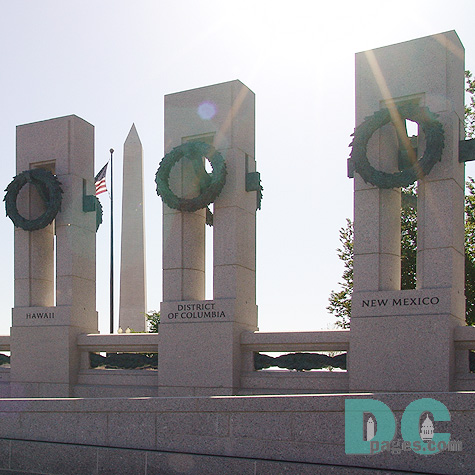 East to West view of granite pillars. American flag and Washington Monument in the background.