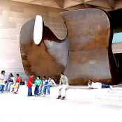 A group of students take a break in front of Henry Moore's bronze work Knife Edge Mirror Two Pieces