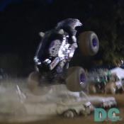 The Engines rev high with big knobby tires spinning over a line of parked junk cars.