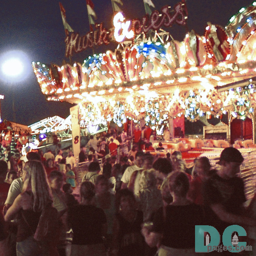 A crowd is forming around the Himalaya amusement ride.