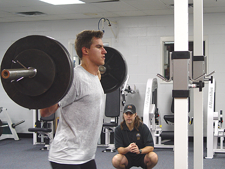 Jim Fox watches to make sure Zubrus is using the correct form during his scwats exercise.