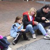Families take a break from walking around to enjoy their food.