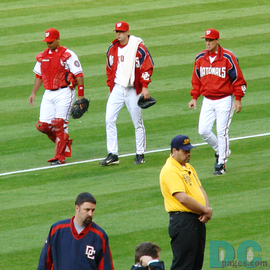 The players head to the dugout for the start of the game.