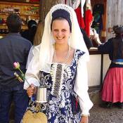 A very beautiful dress, she must be royalty at the festival.