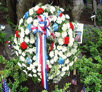 A beautiful wreath placed at the feet of the statued vietnam soldiers, before the Vietnam Wall. 