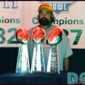 A fan poses with the three Super Bowl trophies won by Coach Gibbs during his first tenure with the Redskins.