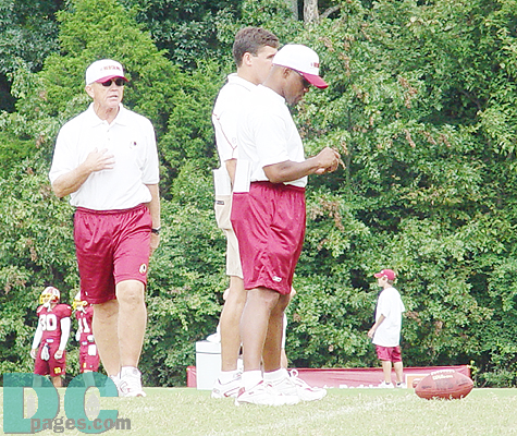 Gibbs and the coaching staff look on while players run drills.