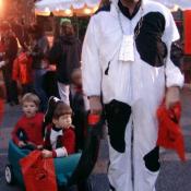 A fatherly cow pulls his boys dressed up as Spiderman and a pirate.