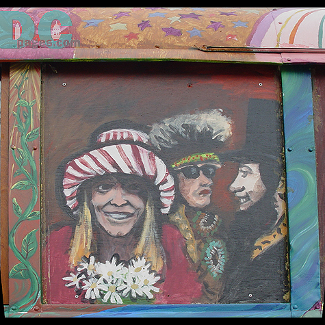 Famous people adorn the side of the vibrantly colored bus.