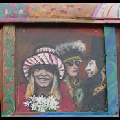Famous people adorn the side of the vibrantly colored bus.