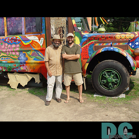Two friends pose in front of the bus.