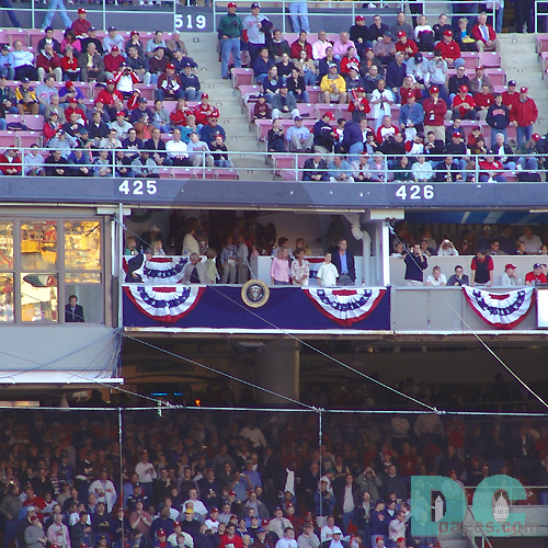 Washington Nationals' Inaugural Home Opener - Presidential Box. President George Bush wraps his arms around to future leaders. A young man says hello to Jenna and Laura Bush.