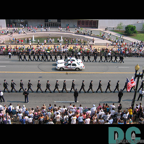 Soldiers marching in perfect formation down the street.