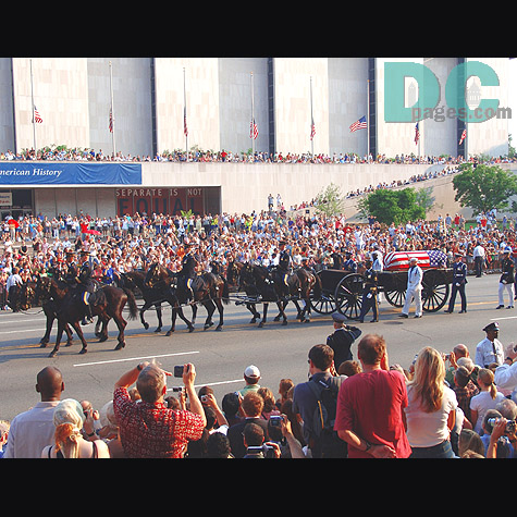 Street bystanders attempt to get a better view of the procession to take picture and video to remember this important event.