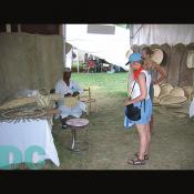 People watch as this Haitian man shows the art of basketry.