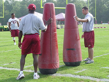 Coaches hold these heavy post to simulate defensive players during the RB drills.