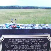 A plaque honoring the victims of Flight 93.  The crash site is near the tree line.