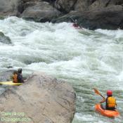 Safety boaters watch the paddler to make sure he/she gets down the rapid.