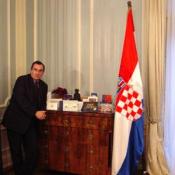 The Croatian Embassys' Aid standing next to a table convered with Christmas cards