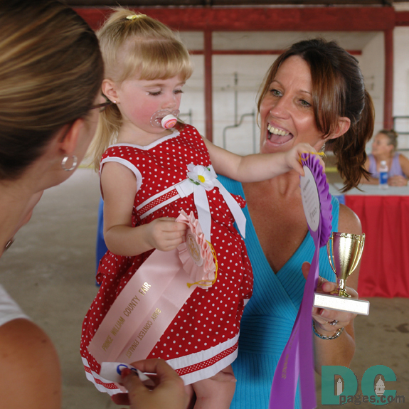 Mother (left) and Grandmother (right) congratulate Prince Willam County Fair baby beauty contest winner.