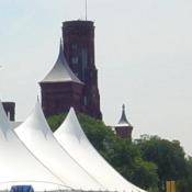 The tents of the Folklife Festival with the Smithsonian Castle towers in the background