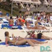 Spring break girls sun tan on Cancun's white sand beaches.
