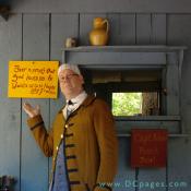 The tavern keeper points to a sign. "Beer is proof that God loves us and Wants us to be Happy." - Ben Franklin.